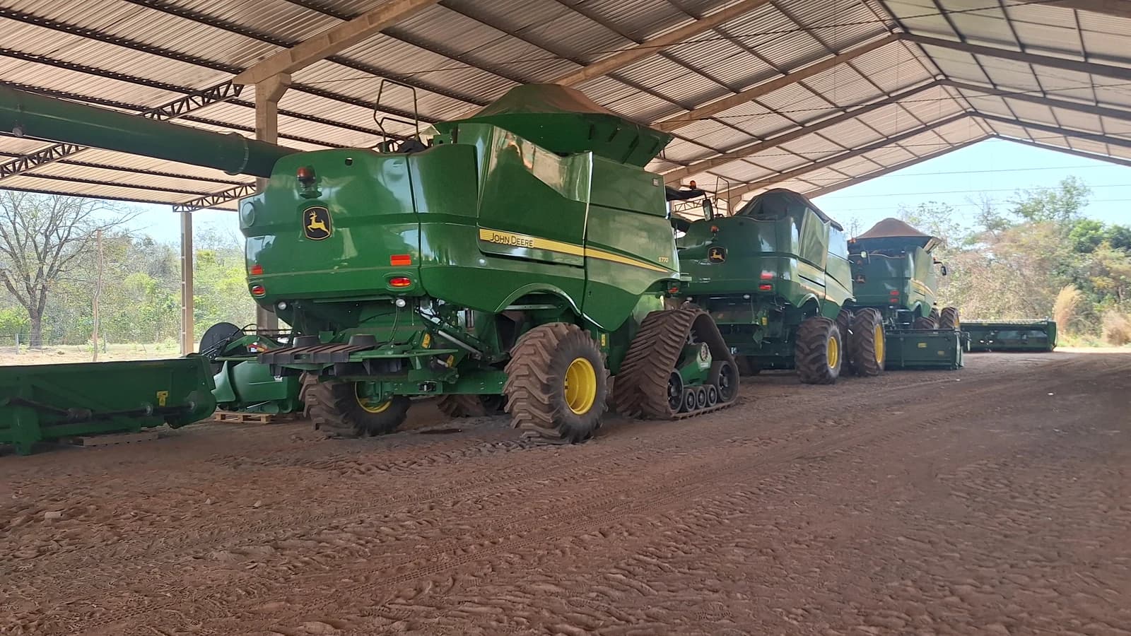 Colheitadeiras John Deere no galpão da operação, com uma S770 em primeiro plano.